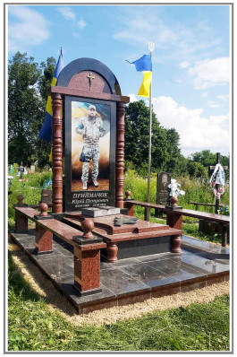 Гранітний пам'ятник військовому з чорного і червоного граніту з огорожею